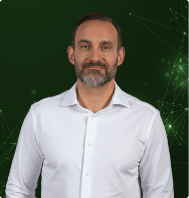 Mann im weißen Hemd vor grünem, digitalem Netzwerkhintergrund als IoT- und Technologieexperte