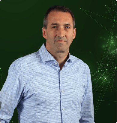 Mann im hellblauen Hemd vor grünem, digitalem Netzwerkhintergrund als Experte für IoT- und Softwarelösungen