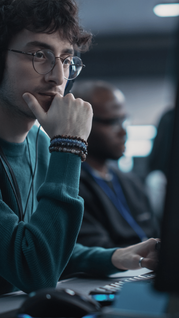 Security-Analyst überwacht Systeme an mehreren Bildschirmen – Protokollierung und Reaktion auf sicherheitsrelevante Ereignisse im IoT