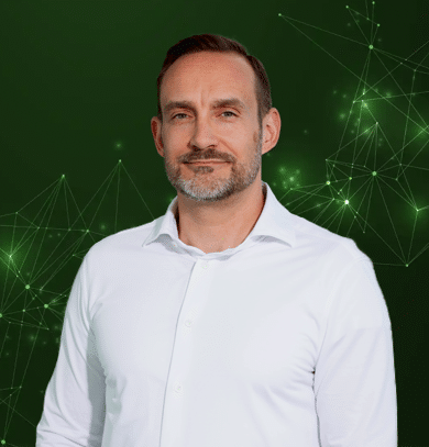 Mann im weißen Hemd vor grünem, digitalem Netzwerkhintergrund als IoT- und Technologieexperte