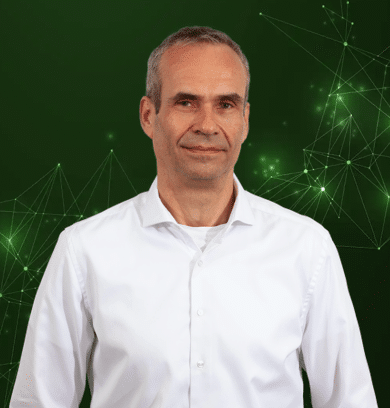 Mann im weißen Hemd vor grünem, digitalem Netzwerkhintergrund als IoT- und Technologieexperte