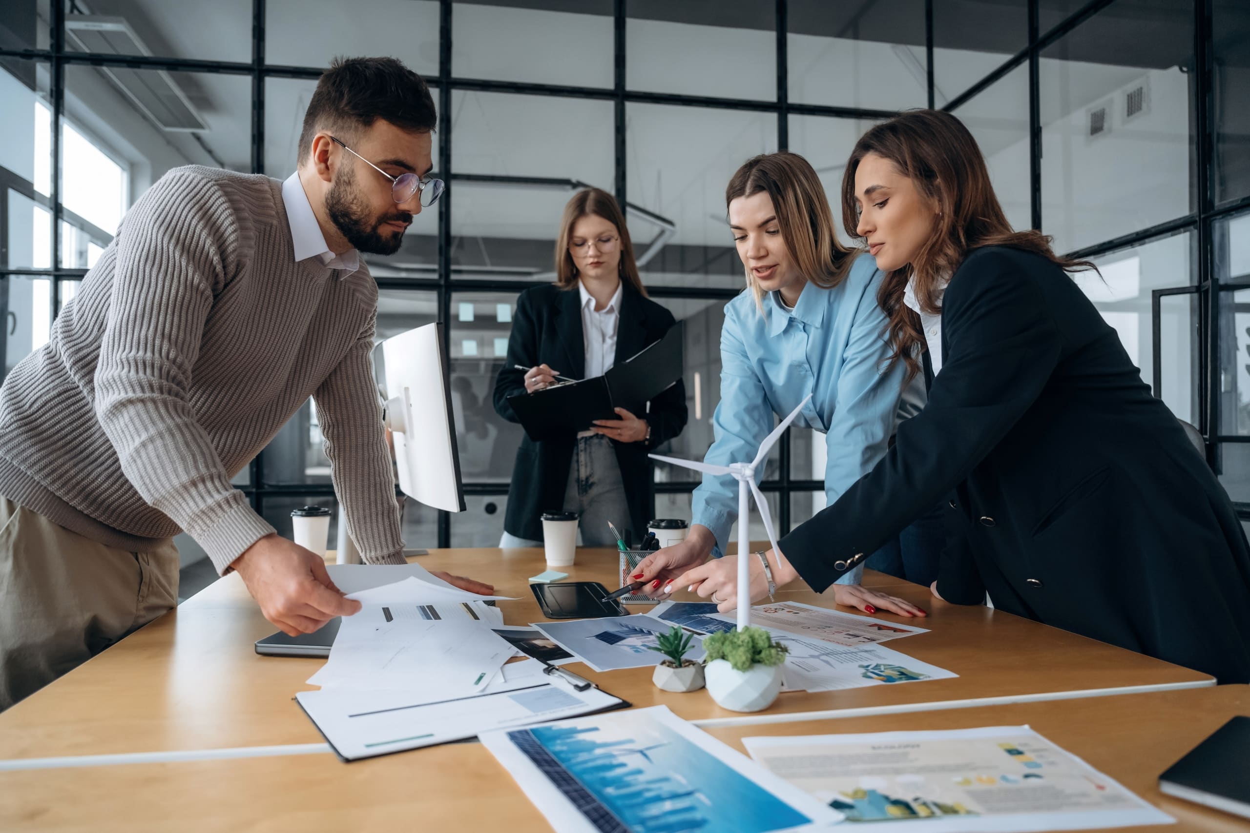 Ein Team bespricht an einem Konferenztisch mit Unterlagen die Schritte zum IoT‑Energiemanagement.