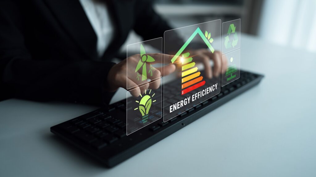 Person bedient eine Tastatur mit holografischem Display: Energieeffizienzskala (A–G) sowie Wind- und Solarenergie-Icons